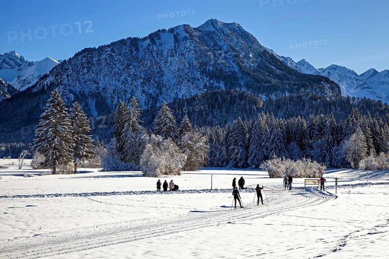 Winter landscape in the snow, cross-country skier on cross-country ski run through snowy landscape, behind mountains of the Allgäu Alps, Oberstdorf, Oberallgäu, Allgäu, Bavaria, Germany, Europe