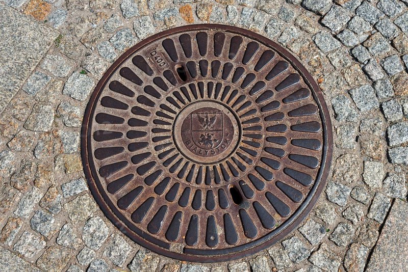Round manhole cover with central pattern on paved surface, manhole cover, Bialystok, Bialystock, Bjelostock, Podlaskie, Poland, Europe