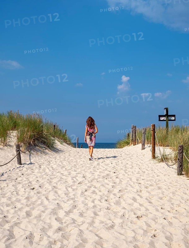 Woman in colourful dress on empty beach, Slovincian National Park, Slowinski Park Narodowy, Poland, Europe