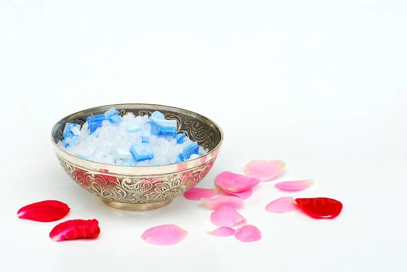 Bath salt in a bowl, rose petals