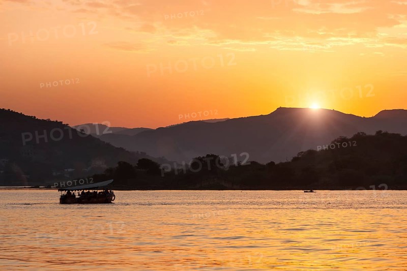 Tourist boat in lake Pichola on sunset. Udaipur, Rajasthan, India, Asia
