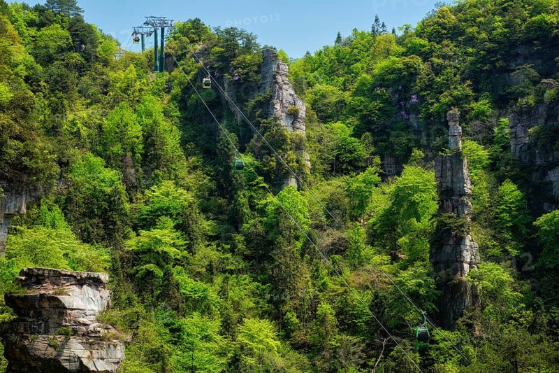 Famous tourist attraction of China, Zhangjiajie stone pillars cliff mountains with cable railway car lift at Wulingyuan, Hunan, China. With camera pan