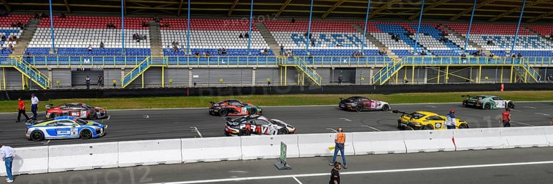 Panoramic photo of part of grid lane with starting grid of racing cars sports cars of GT4 class of racing series GTS Racing, left Audi R8 LMS GT4, middle Porsche Cayman GT4 Clubsport, right Mercedes-AMG GT4 on grid lane start-finish straight for car race GT Sprint, in foreground pit wall, ADAC Racing Weekend, TT Circuit Assen, Assen, province Drenthe, Netherlands