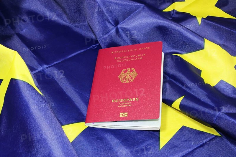 Symbolic image of freedom to travel: German passport on a European flag