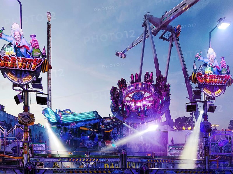 People on the illuminated carousel Mr Gravity in the evening, Cranger Kirmes, Herne, Ruhr area, North Rhine-Westphalia, Germany, Europe