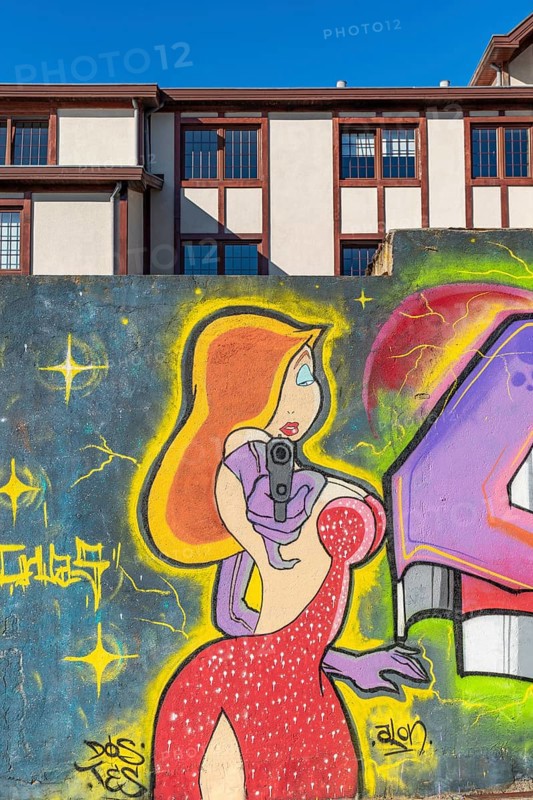 Colourful graffito of a woman with a gun, street art in the city of Punta Arenas, Patagonia, Chile, South America