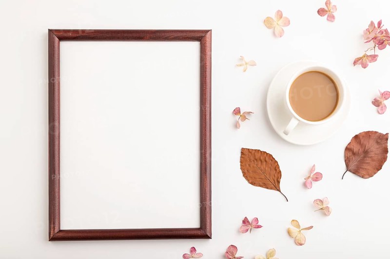 Composition with wooden frame, brown beech autumn leaves, hydrangea flowers and cup of coffee. mockup on white background. Blank, flat lay, top view, still life, copy space