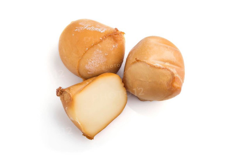 Piece of smoked cheese isolated on white background. Side view, close up