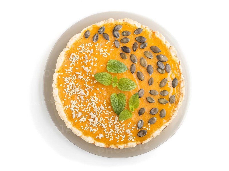 Traditional american sweet pumpkin pie decorated with mint, sesame and pumpkin seeds isolated onwhite background. top view, close up, flat lay
