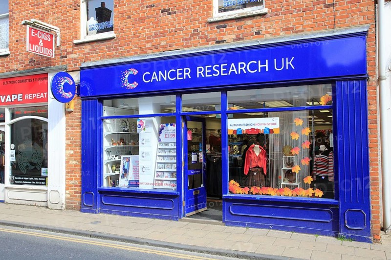 Cancer Research UK charity next to Vaping electronic cigarette shop, East Dereham, Norfolk, England, UK