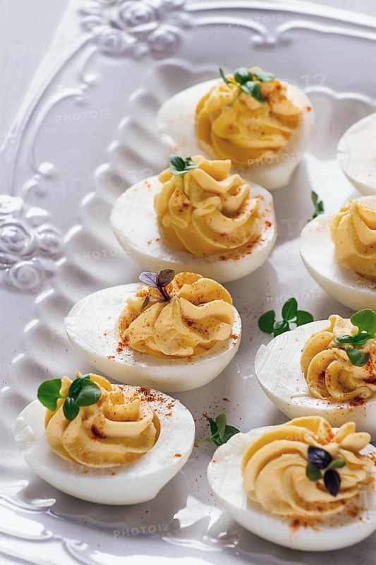 Boiled eggs stuffed with yolk with mayonnaise, on a white plate, selective focus, blurry, close-up, no people