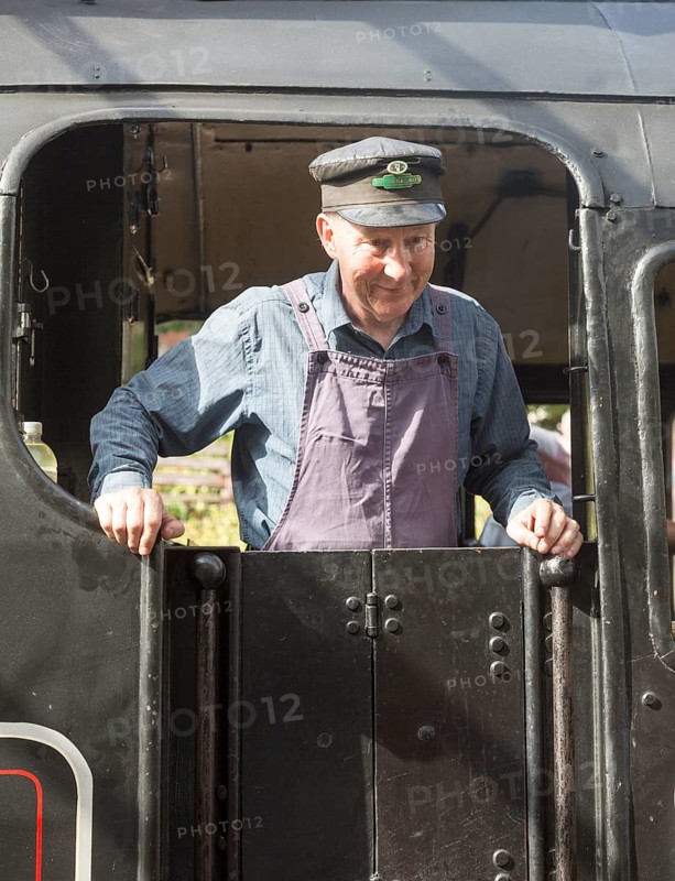 BR Standard Class 4 80104 steam locomotive train engine at railway station, Swanage, Dorset, England, UK portrait of train driver