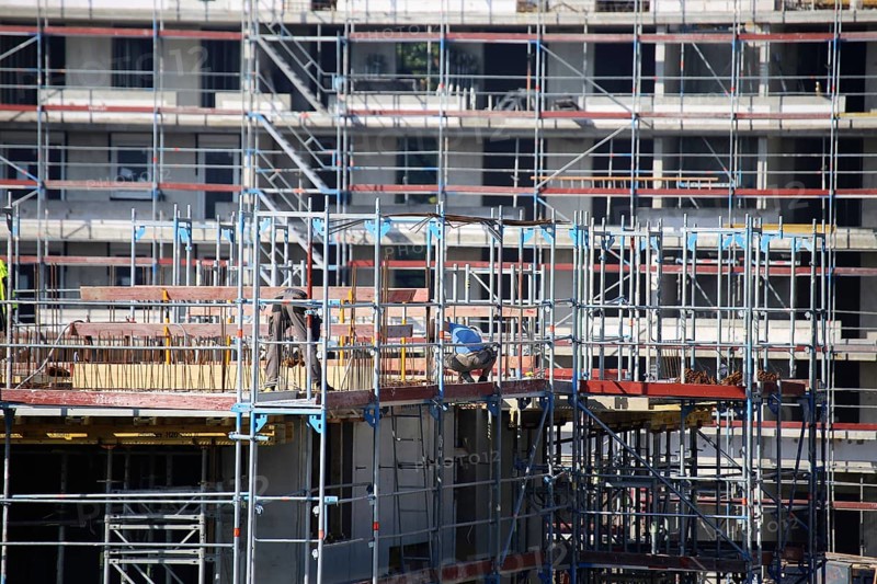 Photo of a large construction site in a newly developed residential area. Several apartment buildings are still under construction
