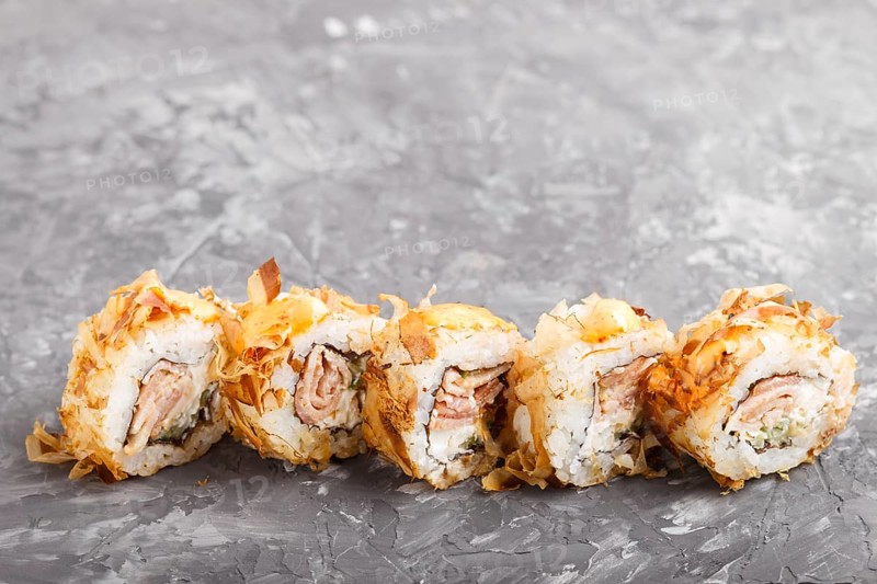 Japanese maki sushi rolls with tuna, cucumber, cheese on black concrete background. Side view, close up, copy space