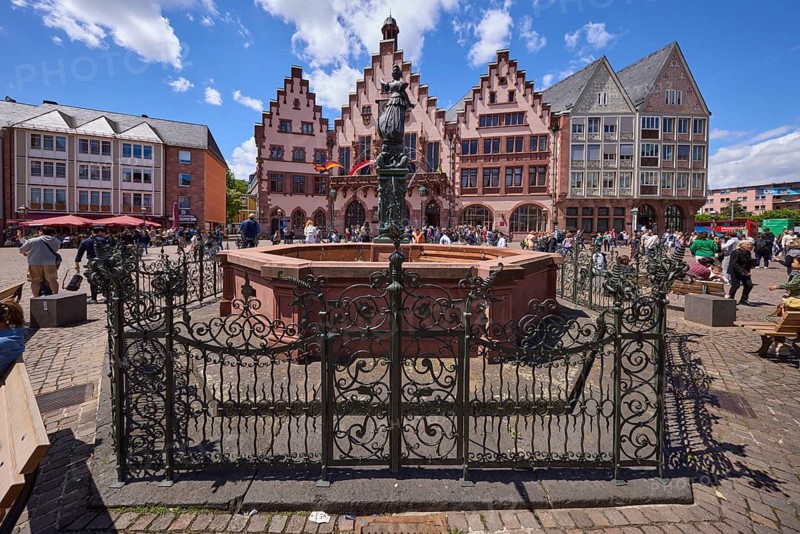 Fountain of Justice and Römer Town Hall on the Römerberg under a blue sky with cumulus clouds in Frankfurt am Main, Hesse, Germany, Europe