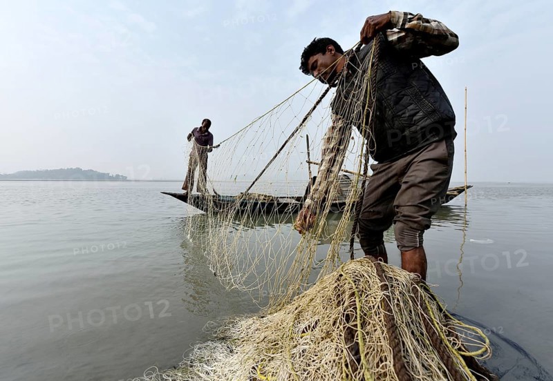 Fisherman cleaning plastics and other materials from their fishing net after fish in the Brahmaputra river in Guwahati, Assam, India on Tuesday, 19 February, 2019