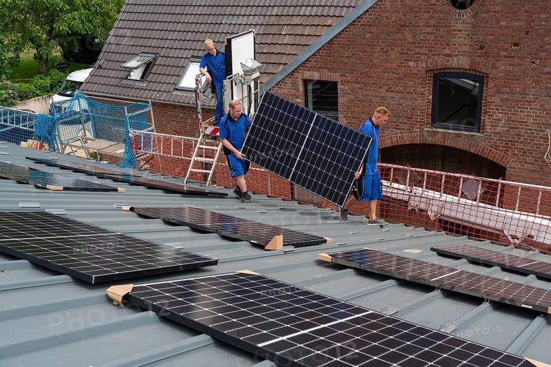 Installation of solar modules on the roof of a barn on a farm, over 240 photovoltaic modules are installed on the roof, North Rhine-Westphalia, Germany, Europe