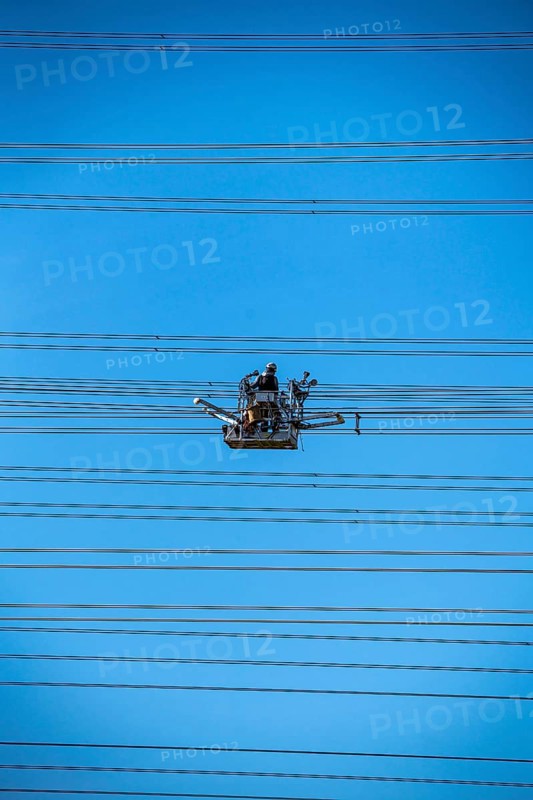 Construction of a new line route, 380 KV extra-high-voltage line between Osterath and Gohr, near Neuss, fitters in line trolleys, on the conductor cables, installing field spacers at great heights, North Rhine-Westphalia, Germany, Europe