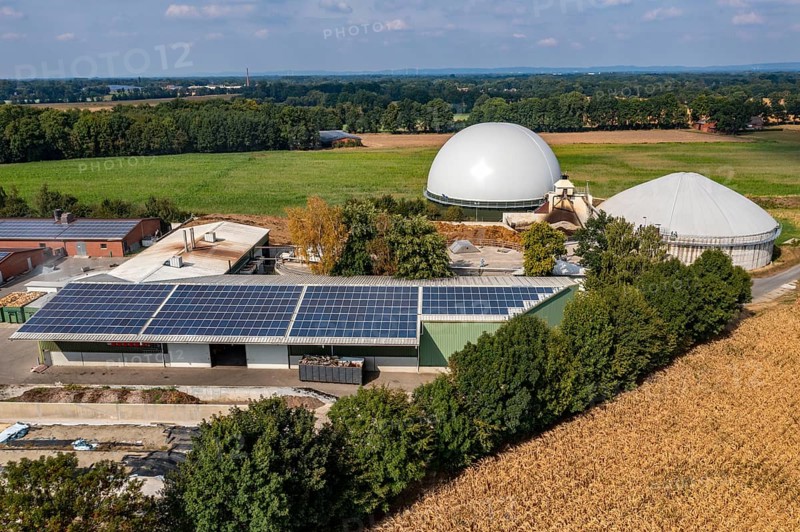 Biogas plant, gas storage, with dome, fermenter tanks for the fermentation process, use of solid manure as energy source, photovoltaic system on farm buildings, on a farm near Lippling, close to Delbrück in East Westphalia, in the district of Paderborn, 1.5 megawatts of electrical power, production of district heating for homes in the region, North Rhine-Westphalia, Germany, Europe