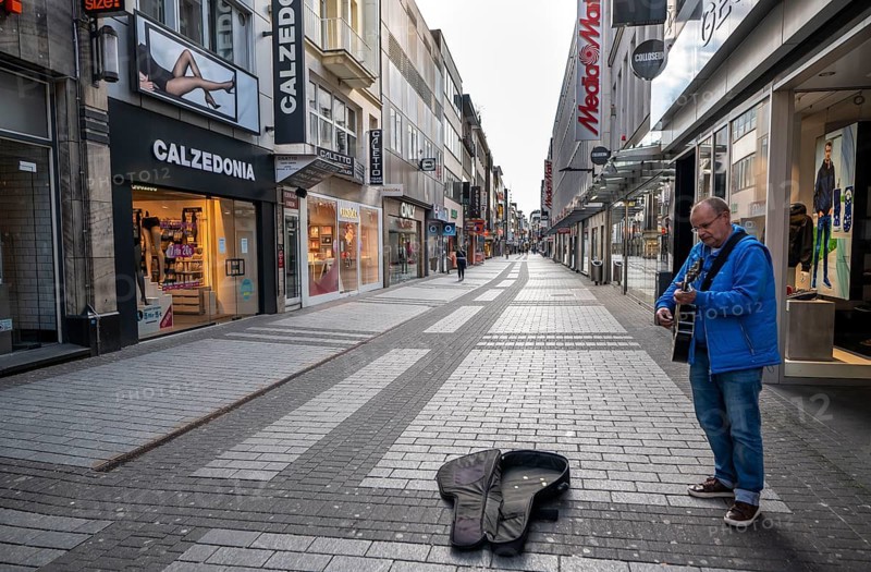 Effects of the coronavirus crisis, empty shopping street, lonely street musician, around 1400 on Saturday, normally thousands of people go shopping here at this time, Hohe Straße in Cologne, Germany, Europe