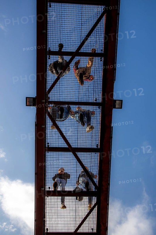 Lattice walkway, people walk over a walkway at a height of a good 15 metres, made of steel lattice, seen from below, viewing platform