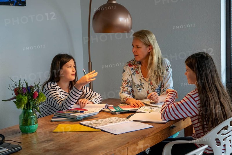 Homeschooling, during the lockdown in January 2021, mother helps her two daughters, at home, learning, school closures, distance learning, effects of the corona crisis in Germany
