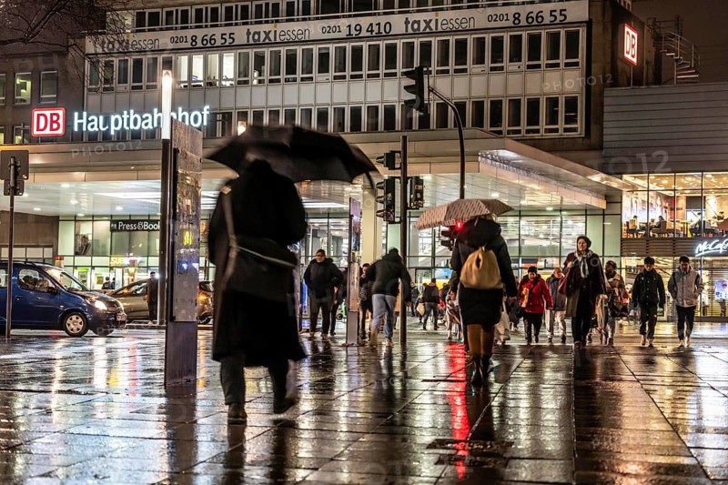 Passers-by at a pedestrian crossing, at the main railway station, rainy weather, city centre, in the evening, Essen, North Rhine-Westphalia, Germany, Europe