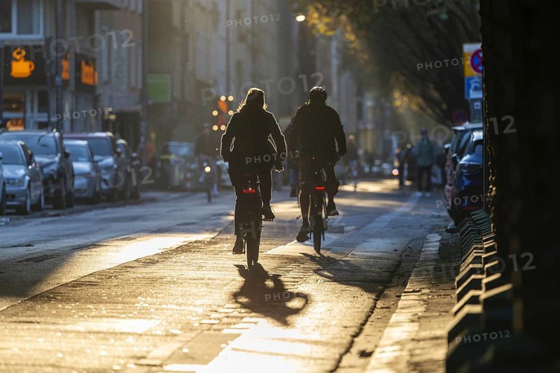 Cyclists in oblique sunlight in November, poor visibility, danger of glare, cycle lane, cyclists have priority over motor traffic, Cologne, North Rhine-Westphalia, Germany, Europe