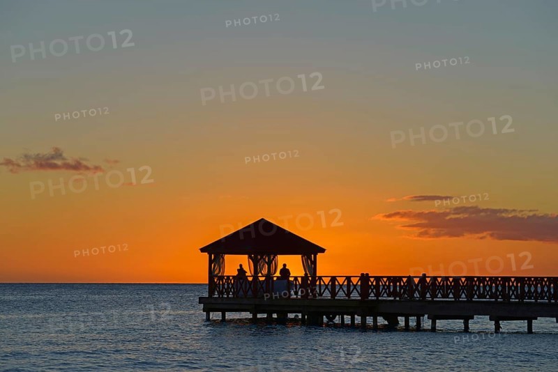 Silhouette of a jetty against the orange coloured sky at dusk without visible people, Dominicus beach, Bayahibe, Dominican Republic, Hispaniola, Caribbean, America, Central America