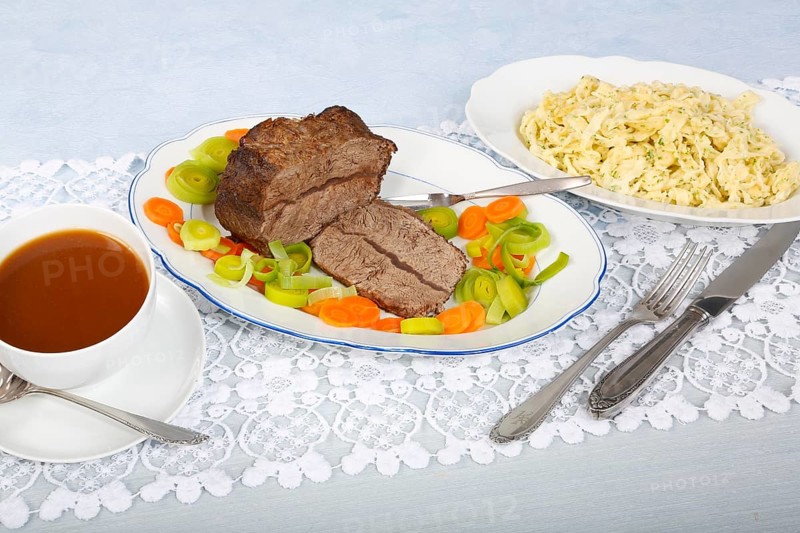 Swabian cuisine, roast beef, roast ox, herb spaetzle, meat dish, gravy, carrot vegetables, leek, serving platters, hearty, savoury, typical Swabian, home cooking, traditional cuisine, food photography, studio, Germany, Europe