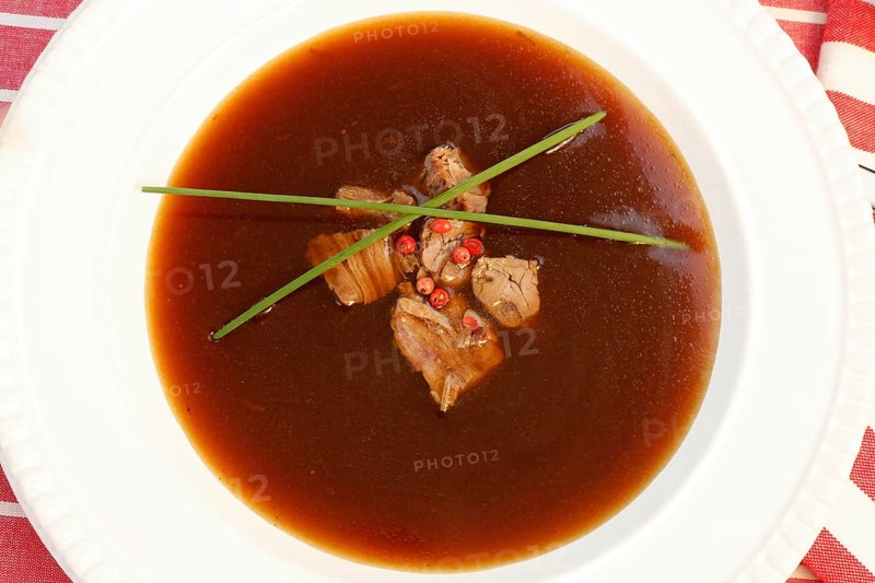 Southern German cuisine, oxtail soup with red pepper in a soup plate, bound soup, meat soup, chives, soup plate, traditional cuisine, speciality, food photography, studio, Germany, Europe