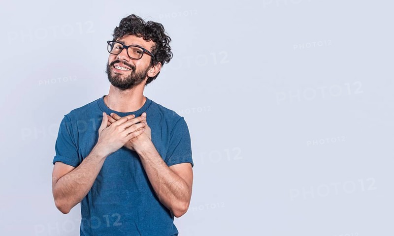 Grateful people smiling with hands on chest. Positive looking friendly handsome man with charming sincere smile feeling thankful, relaxed person with thanks gesture with hands on chest