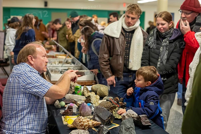 Detroit, Michigan - A teacher explains rocks and minerals to visitors at Wayne State University's Geology Mineral Museum on Noel Night. The annual Noel Night at the start of the holiday season in Detroit features open houses by arts and cultural institutions, churches, and small businesses.