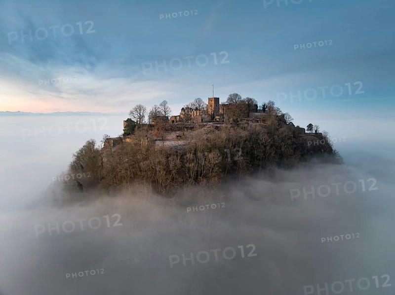 Aerial view of the Hegau volcano Hohentwiel with the upper fortress ruins in front of sunrise, rising out of the fog during an inversion, the Swiss Alps on the horizon, district of Constance, Baden-Württemberg, Germany, Europe