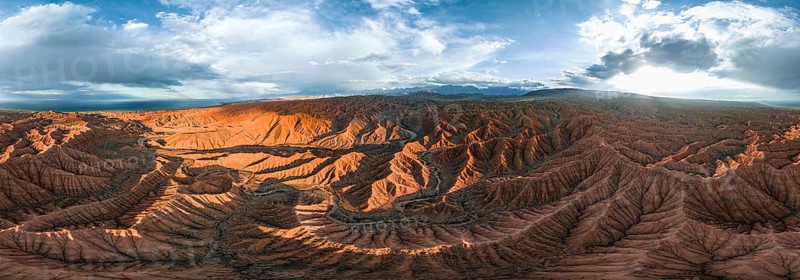 Panorama, landscape of eroded hills at Lake Issyk Kul, badlands at sunset, mountain peaks of the Tian Shan Mountains in the background, aerial view, Canyon of the Forgotten Rivers, Issyk Kul, Kyrgyzstan, Asia