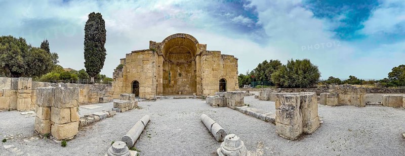 Panorama of view of ancient ruins of Titus Basilica, in the foreground remains of stones foundation walls of portal next to columns in the background chancel of early Christian basilica from 6th century in excavation site remains of ancient Roman city Gortys Gortyn former capital of Crete, Gortyna, Crete, Greece, Europe