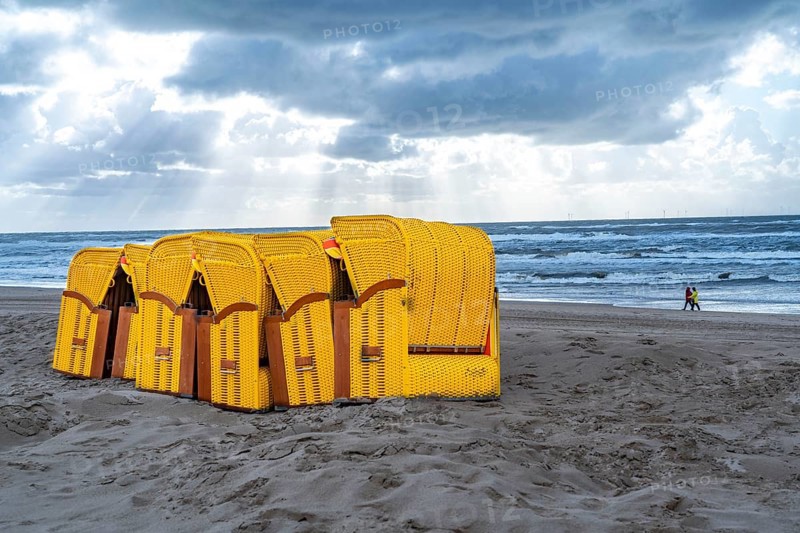 End of the season on the beach, dark storm clouds, choppy sea, autumn on the North Sea in North Holland, near Egmond aan Zee, beach chairs ready for transport to winter storage, Netherlands