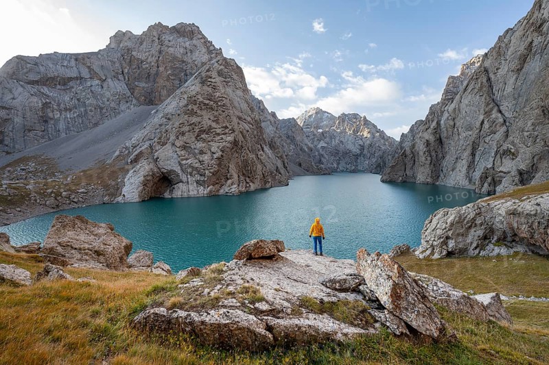 Tourist at the blue mountain lake between rocky steep mountain peaks, Kol Suu Lake, Sary Beles Mountains, Naryn Province, Kyrgyzstan, Asia