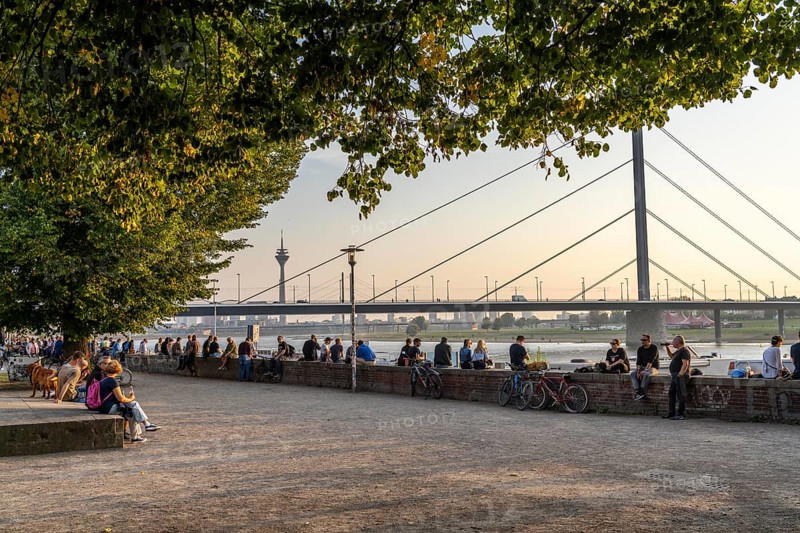 Rhine promenade on Joseph-Beuys-Ufer, view of Oberkassler Bridge, Fortuna Büdchen, kiosk on the banks of the Rhine, popular meeting place, especially at sunset, Düsseldorf, North Rhine-Westphalia, Germany, Europe