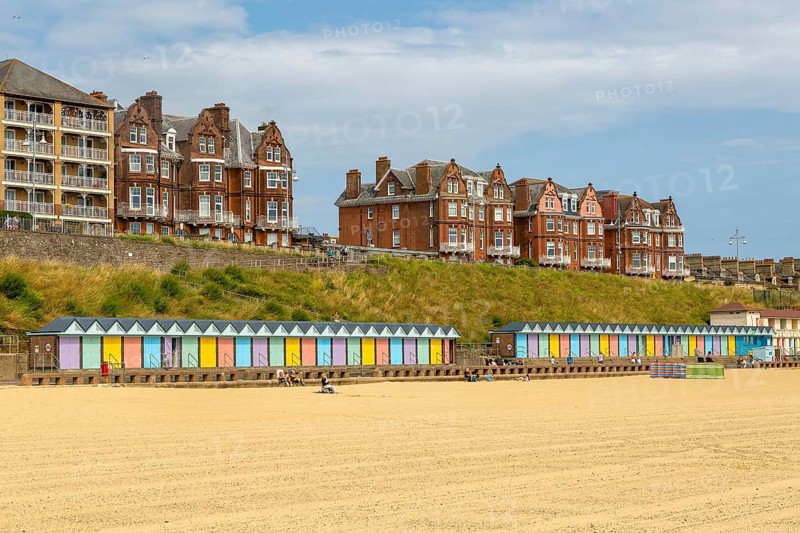 Colourful beach huts and historic clifftop buildings, South Beach, Lowestoft, Suffolk, England, UK