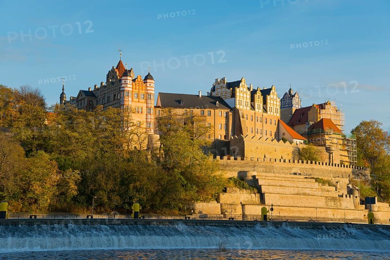 A castle on a hill above a river in autumnal surroundings with blue sky and sunset, Bernburg Castle, Bernburg an der Saale, Saxony-Anhalt, Germany, Europe