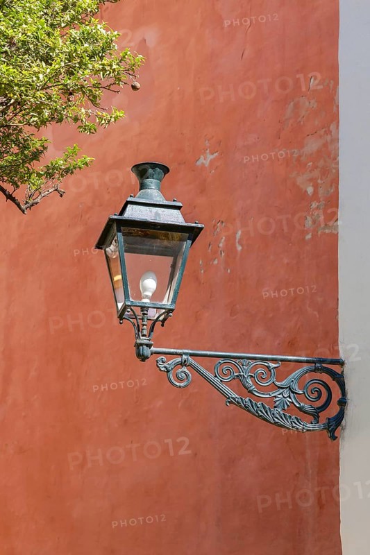 Lantern in front of a red house wall, Seville, Andalusia, Spain, Europe
