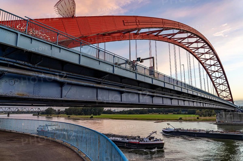 The Bridge of Solidarity, the longest tied-arch bridge in Germany, over the Rhine from Duisburg-Hochfeld to DU-Rheinhausen, the road bridge is dilapidated and has to be rebuilt, many thousands of lorries from the Logport port and cars use the bridge every day, new construction by 2040, cargo ships, behind the Duisburg-Hochfeld railway bridge, Duisburg, North Rhine-Westphalia, Germany, Europe