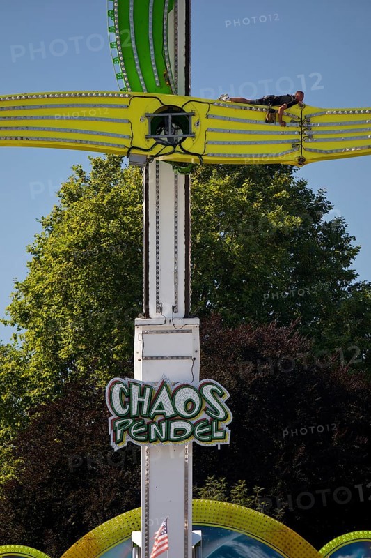 An employee works at the Chaos Pendulum ride at a dizzying height, Cranger Kirmes, Herne, Ruhr area, North Rhine-Westphalia, Germany, Europe