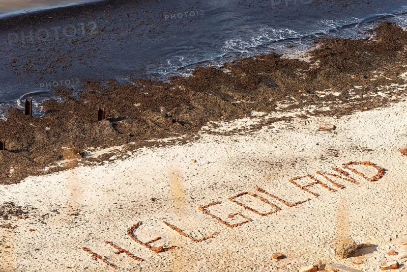 Helgoland lettering laid with stones on the northern beach, seaweed, coastal fringe, offshore island of Helgoland, North Sea, Pinneberg district, Schleswig-Holstein, Germany, Europe