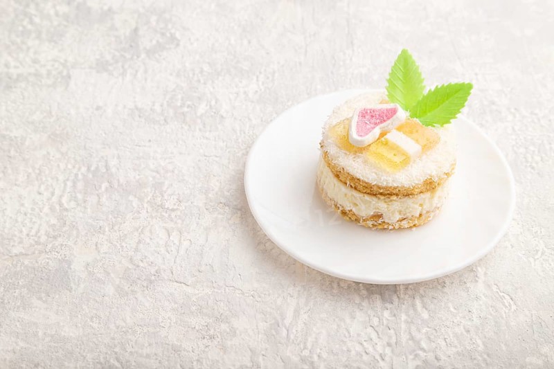 Decorated cake with milk and coconut cream on a gray concrete background. Side view, copy space, close up