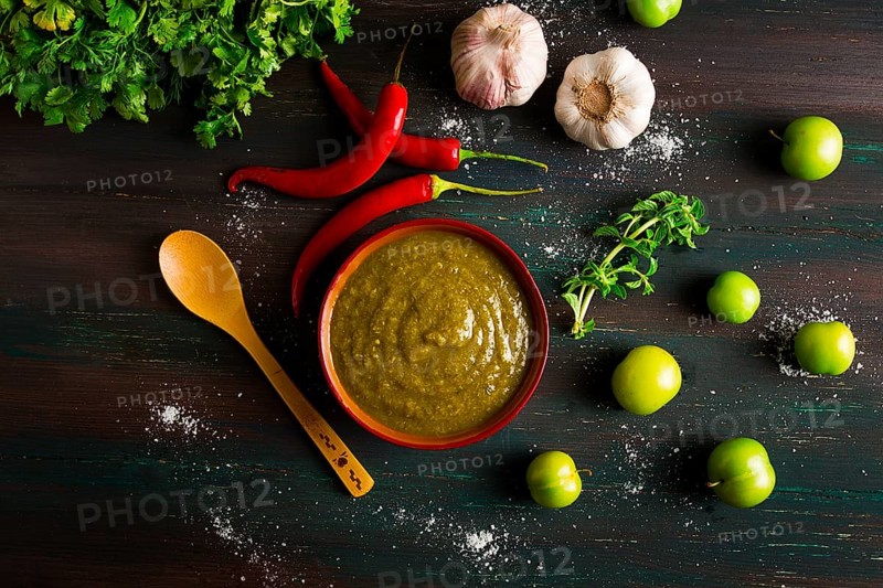 Tkemali sauce, traditional Georgian cuisine, green cherry plum, with ingredients for sauce, cilantro, mint, hot pepper, garlic, on a wooden table, close-up, rustic, food background, no people, selective focus, sauce, green sauce, tkemali, georgian cuisine, homemade