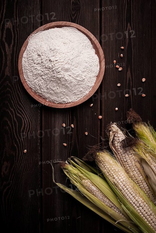 Corn cobs, corn flour, on a wooden table, top view, close-up, rustic, selective focus, dairy corn