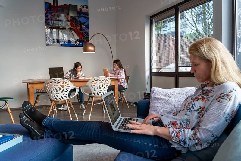 Homeschooling, during the lockdown in January 2021, children learning at home for school, a girl in video lessons with her class, her mother is in the home office and works on her laptop with video chat, school closures, distance learning, effects of the corona crisis in Germany
