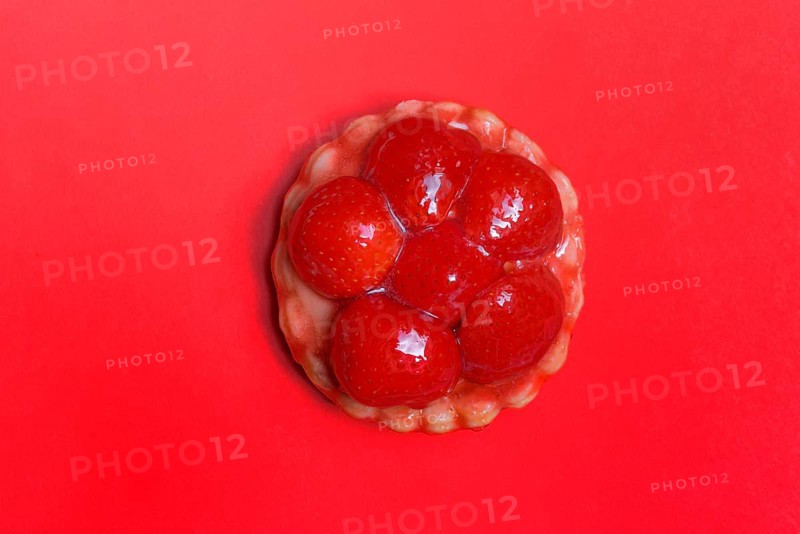 Strawberry tartlets on a red background, fruit cake